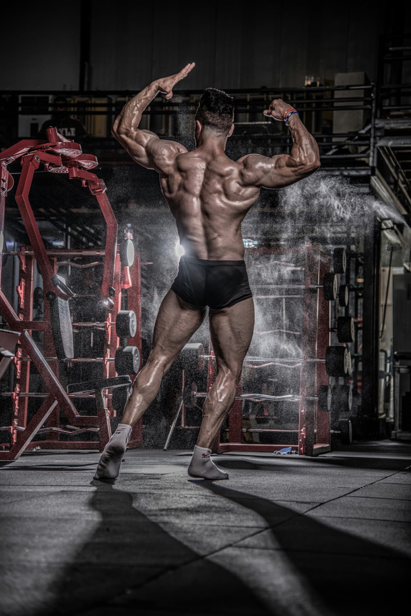 Bodybuilder showing front presentation on stage during a competition